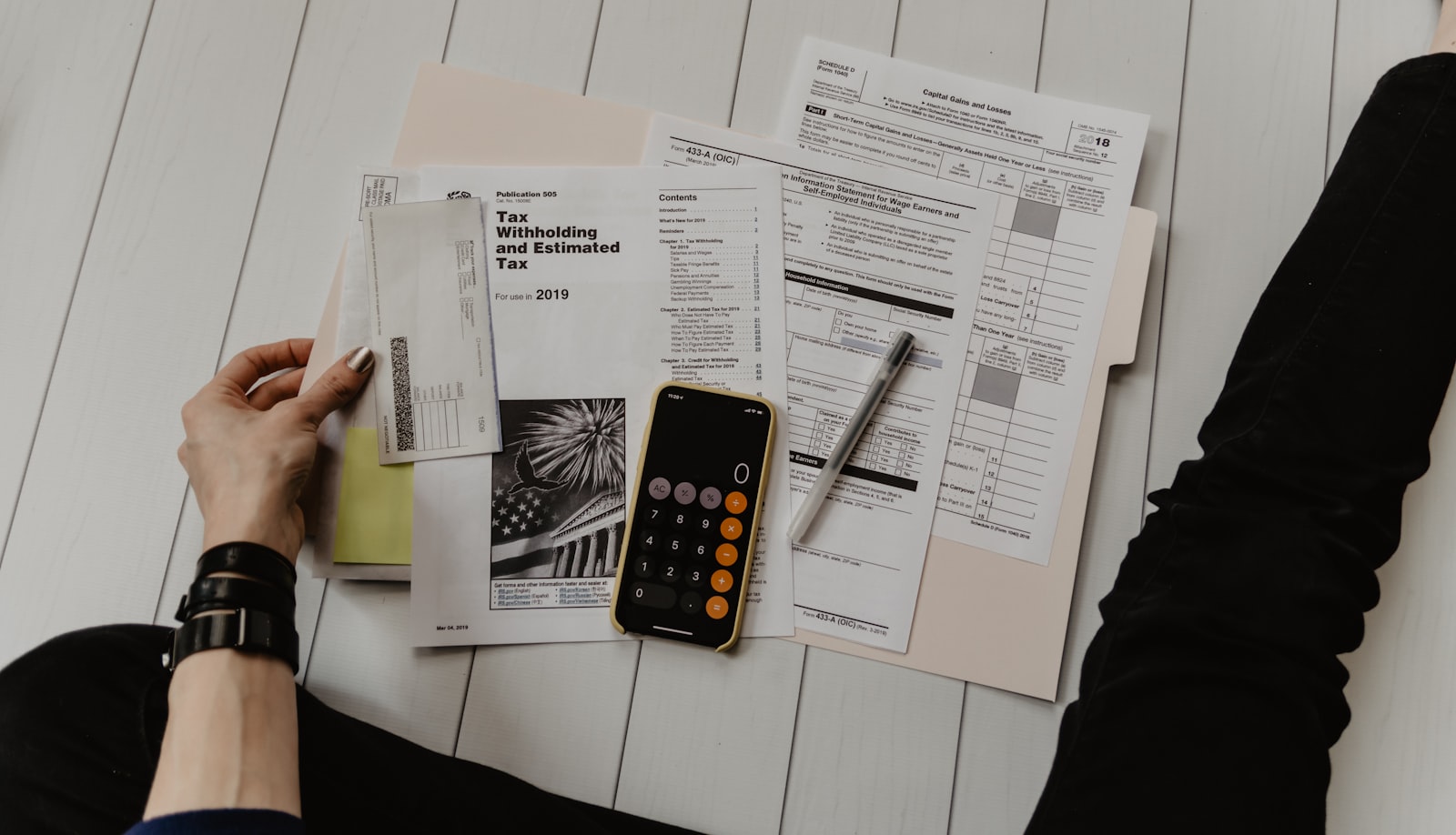 Documentos financieros, calculadora y notas sobre un escritorio de trabajo